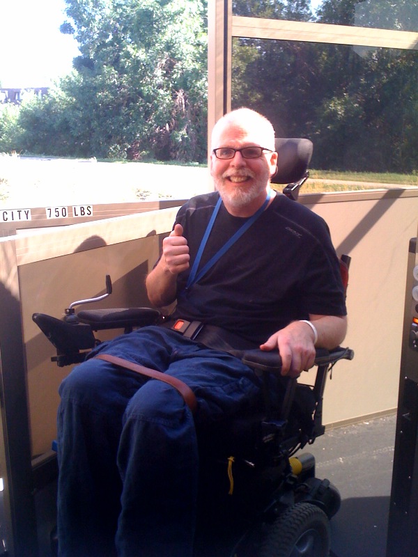 Image of Larry Seidl, one of our webmasters, in his wheelchair on our lift elevator.